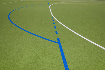Lines in white and blue of a grass hockey field, no person
