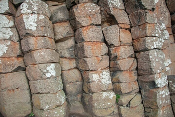 Red basaltic prisms at the Giant's Causeway natural wonder located in County Antrim on the north coast of Northern Ireland, UK