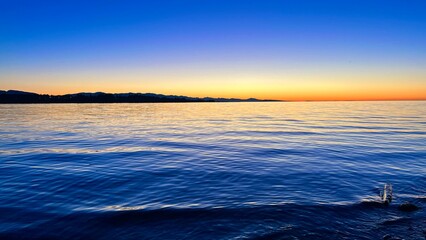 sunset on Ocean Calmness and silence is like a lake or sea on resting in trailers on the shore bright colors of dark blue orange stripe on the horizon from sun rich space for text travel advertising