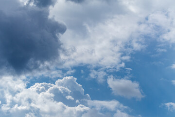 High layered white epic clouds on blue sky. Heavenly cloudscape background