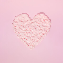 Heart from whipped cream on pink background. Love is sweet concept.