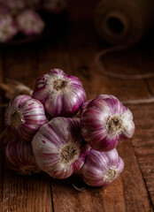 Fresh violet garlic bunch on a wooden rustic background. Harvesting concept.