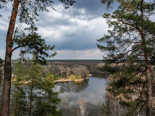 Obraz premium Scenic river bank with pine trees and epic cloudscape. Cossack mountain, Korobovy Hutora (Gomilshanski forest, Koropove village) on Siverskyi Donets River in Ukraine
