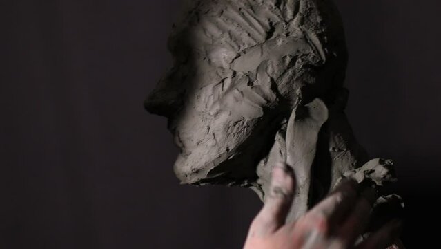 Man sculptor creates sculpt bust clay human woman sculpture. Statue craft creation workshop.