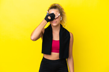 Sport woman with towel isolated on yellow background covering eyes by hands. Do not want to see something