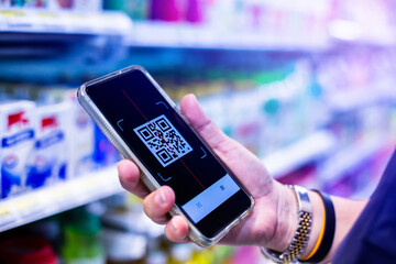 Qr code tag on smartphone with blurry products on shelves in supermarkets. Scan the QR code with mobile phone to pay