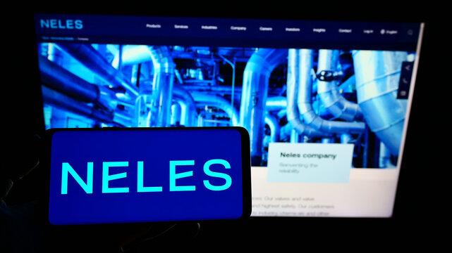 Stuttgart, Germany - 01-06-2022: Person holding smartphone with logo of Finnish flow control company Neles Oyj on screen in front of website. Focus on phone display.