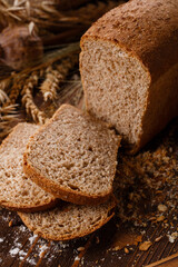 Close up of sliced rye bread on dark wooden background. Homemade baking.