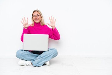 Young caucasian woman with laptop sitting on the floor counting ten with fingers