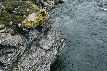 Rock next to streaming glacier water in northern Sweden