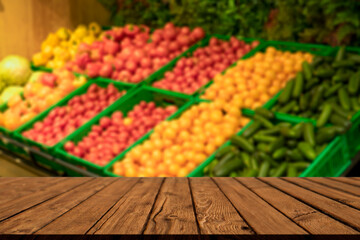 Supermarket table background. A counter with blurred vegetables and empty wooden table. Grocery, food, products, retail concept. 