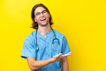 Young surgeon caucasian man isolated on yellow background presenting an idea while looking smiling towards