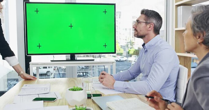 Business people looking at chromakey screen in meeting discussion in a modern office. Team of employees talking with a green screen display or presentation, template and mockup, copy space.