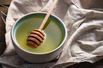 Herbal mint tea cup Transparent glass dark background wooden table still life honey bowl metal kettle teapot spoon cozy