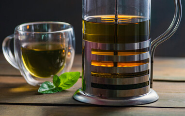 Herbal mint tea cup Transparent glass dark background wooden table still life honey bowl metal kettle teapot spoon cozy