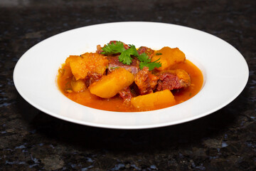 Dry meat with pumpkin, traditional Brazilian rustic dish. Black background