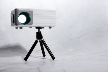 mini projector for home on tripod on light background