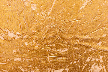 Textured golden stucco background with scratches