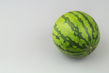 Whole watermelon on gray background with copy space for text.