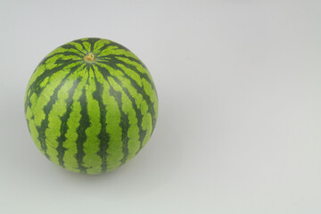 Whole watermelon on gray background with space for text.	