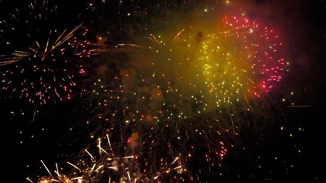Festive beautiful fireworks in the night sky explode with colorful bright lights. New year and christmas, celebration