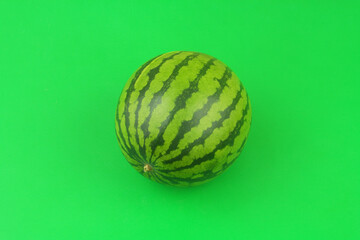 Whole watermelon on green background