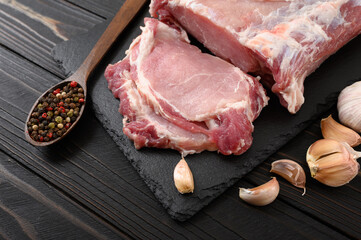 A large piece of pork loin on a rustic dark background.
