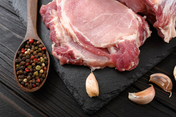 A large piece of pork loin on a rustic dark background.