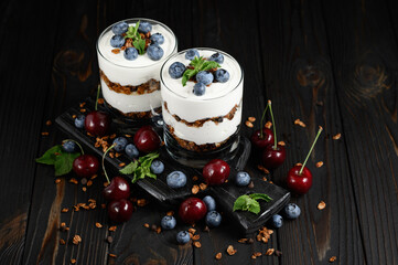 Homemade layered dessert with fresh blueberry, cherry, cream cheese or yogurt, granola.