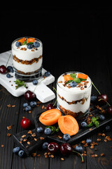 Homemade layered dessert with fresh apricot, blueberry, cherry, cream cheese or yogurt, granola.