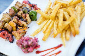 Fried potatoes and fish with vegetables