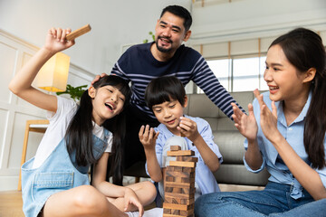 Happy asian family dad and child son building constructor from blocks.Loving parents having fun with  kids in the living room at home.
