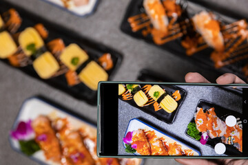 Sashimi sushi set with soy on black background.Assorted sushi set served on dark stone slate background. Mobile phone camera top view.