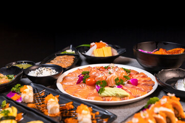 Sashimi sushi set with soy on black background.Assorted sushi set served on dark stone slate background. Top view