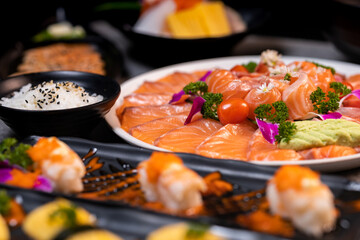 Sashimi sushi set with soy on black background.Assorted sushi set served on dark stone slate background. Top view