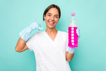 Young cleaner hispanic woman isolated on blue background showing a mobile phone call gesture with fingers.