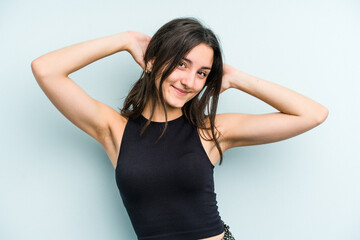 Young caucasian woman isolated on blue background stretching arms, relaxed position.