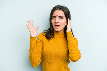 Young caucasian woman isolated on blue background screaming with rage.