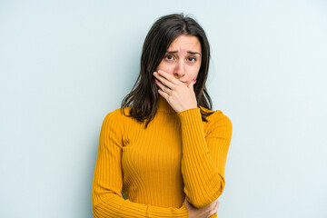 Young caucasian woman isolated on blue background scared and afraid.