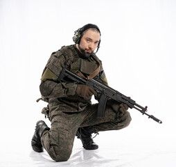 soldier in the studio on a white background. a man in military uniform with a rifle or machine gun....