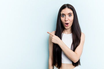 Young caucasian woman isolated on blue background pointing to the side