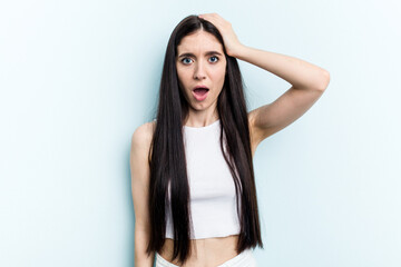 Young caucasian woman isolated on blue background being shocked, she has remembered important meeting.