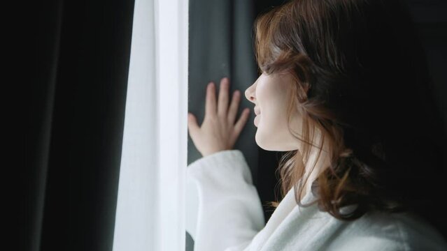 Close up beautiful young woman opening curtains on window in morning and ready to start a new day feel happy smiling. Slow motion