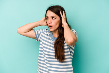 Young caucasian woman isolated on blue background screaming, very excited, passionate, satisfied with something.