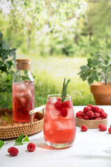 Summer refreshing non-alcoholic cocktails. Raspberry lemonade garnished with fresh rosemary. Summer raspberry beverage with sparkling water. Copy space.
