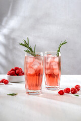Summer refreshing non-alcoholic cocktails. Raspberry lemonade garnished with fresh rosemary. Summer raspberry beverage with sparkling water. Copy space.
