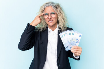 Middle age business caucasian woman holding bank notes isolated on white background showing a disappointment gesture with forefinger.