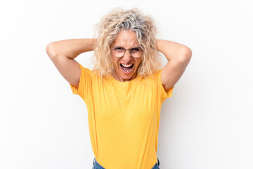 Middle age caucasian woman isolated on white background covering ears with hands trying not to hear too loud sound.