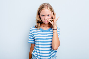 Caucasian teen girl isolated on blue background with fingers on lips keeping a secret.