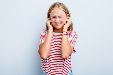 Caucasian teen girl isolated on blue background covering ears with fingers, stressed and desperate by a loudly ambient.